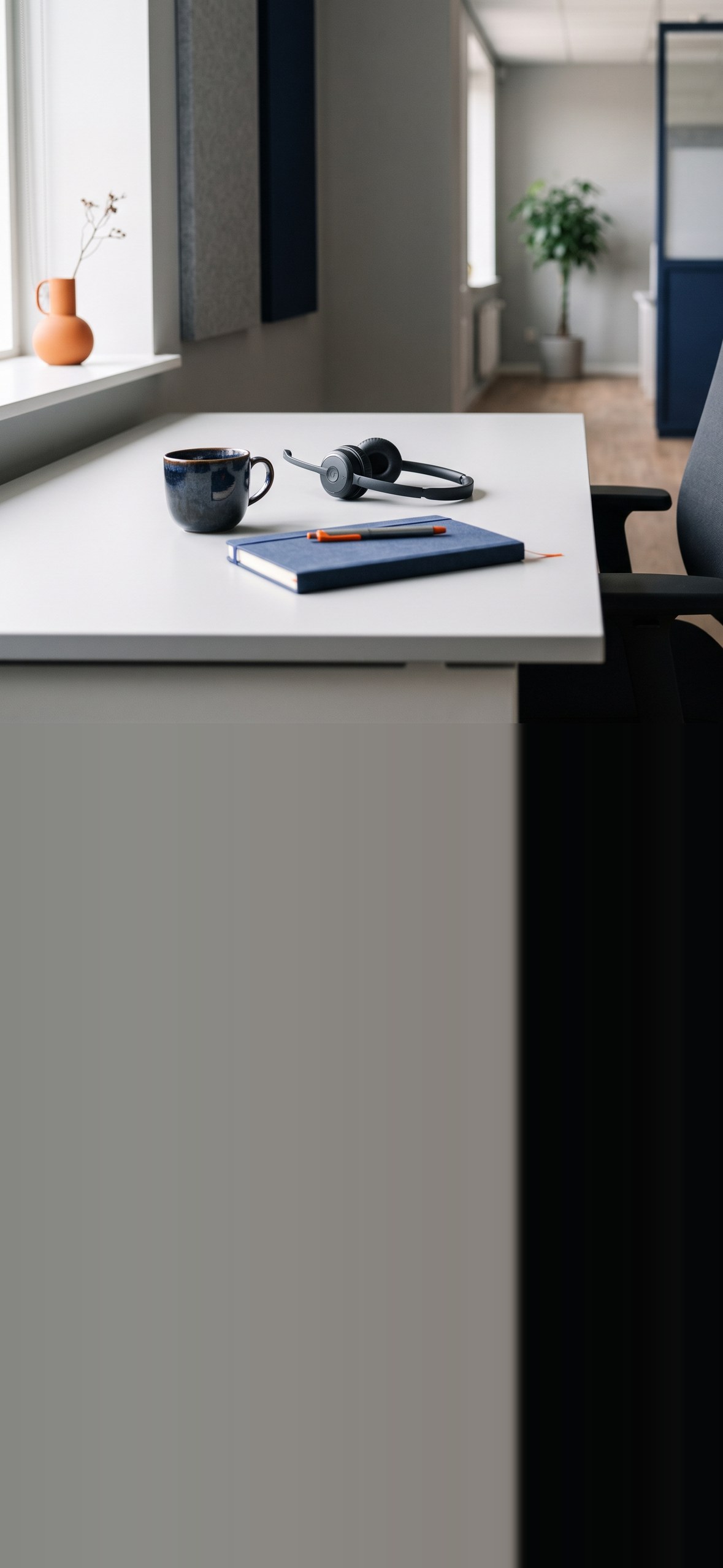 Een verlaten klantenservicebalie in een licht kantoor, met een headset naast een notitieboek
